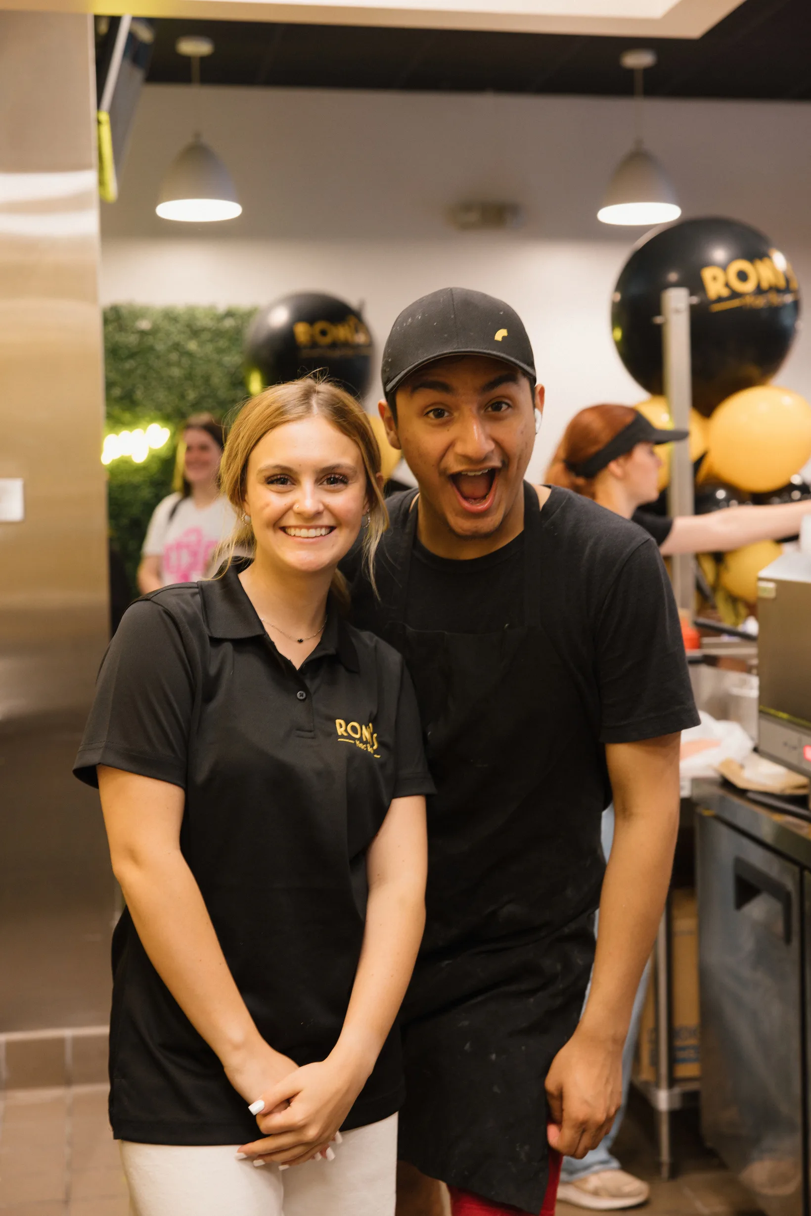 Two smiling Roni’s Mac Bar team members in a restaurant